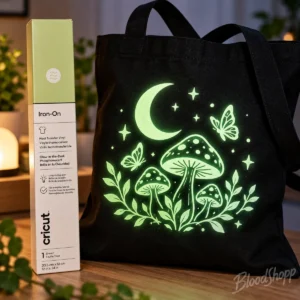 Bolsa negra de tela con diseño de hongos y luna iluminados en verde como ejemplo de vinil Cricut fosforescente